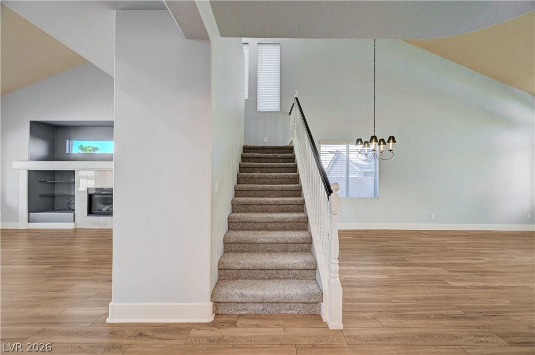 8908 Sheep Ranch Court, Las Vegas, NV 89143 A carpeted staircase separates the open living areas under soaring vaulted ceilings.