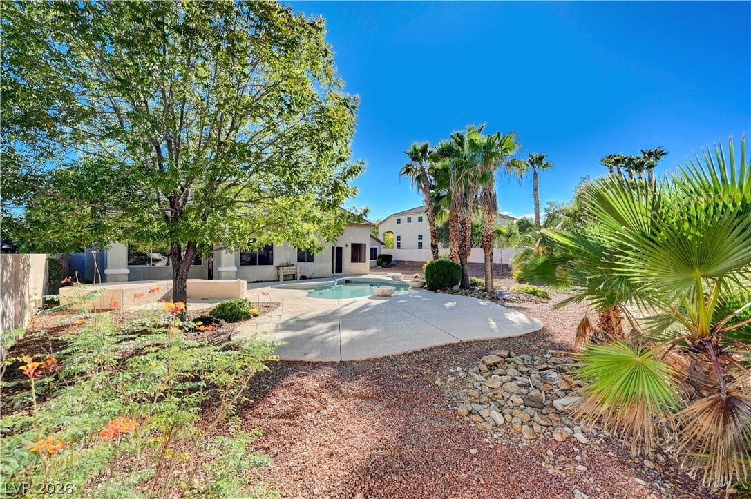 8908 Sheep Ranch Court, Las Vegas, NV 89143 Mature trees and low-maintenance desert plantings surround a curved swimming pool and concrete patio.