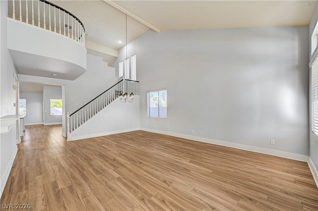 8908 Sheep Ranch Court, Las Vegas, NV 89143 Soaring vaulted ceilings and warm wood-style flooring anchor this open, sunlit living area.