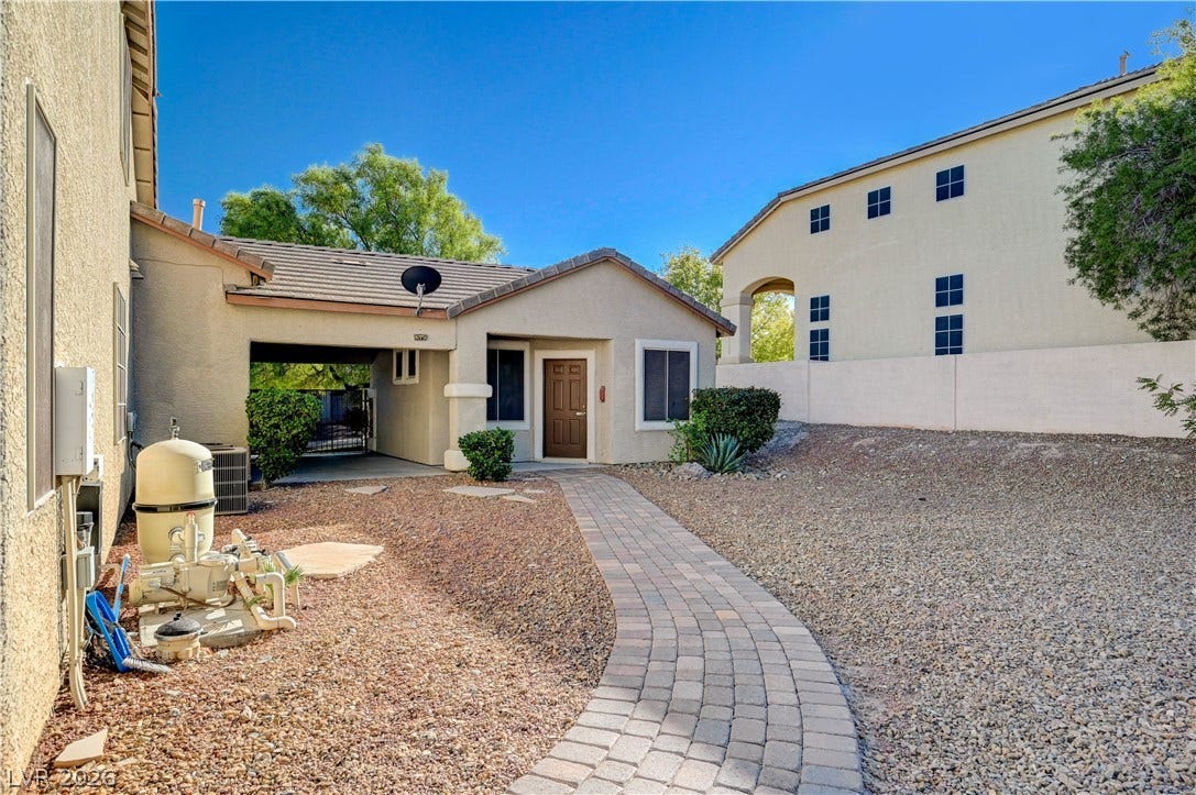 8908 Sheep Ranch Court, Las Vegas, NV 89143 A curved paver walkway leads directly to the private entrance of this stucco home.