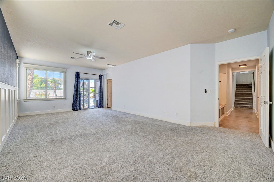 8908 Sheep Ranch Court, Las Vegas, NV 89143 Plush carpeting and wainscoting detail enhance this versatile, light-filled living area.