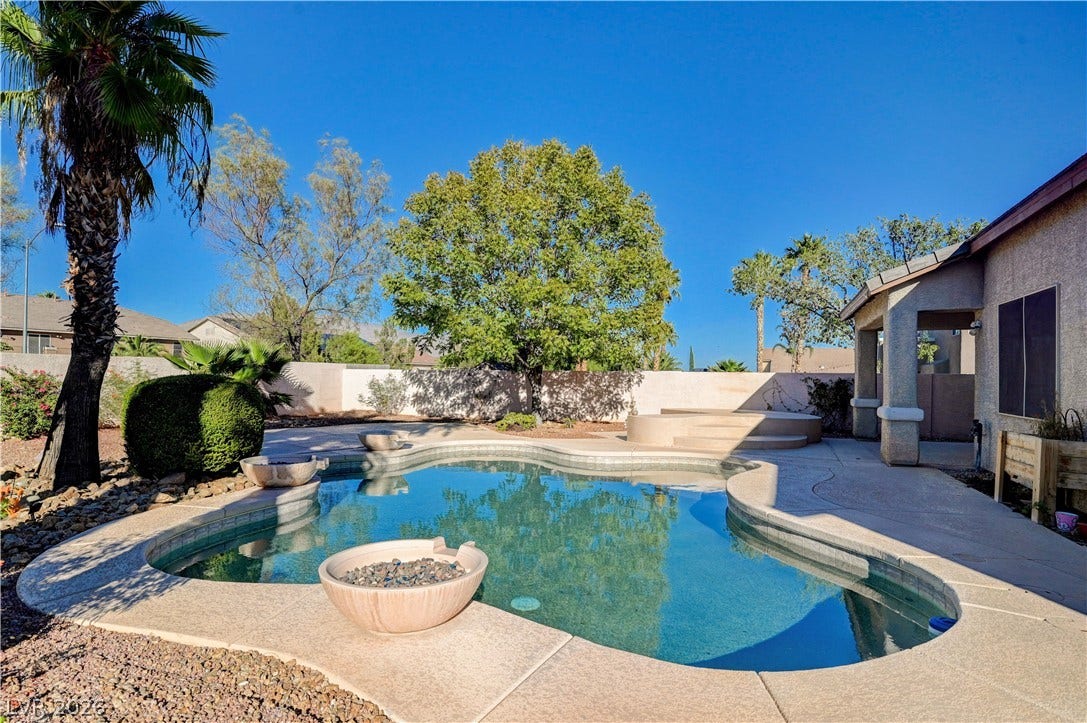 8908 Sheep Ranch Court, Las Vegas, NV 89143 An inviting backyard oasis features a sparkling custom pool framed by a spacious patio.