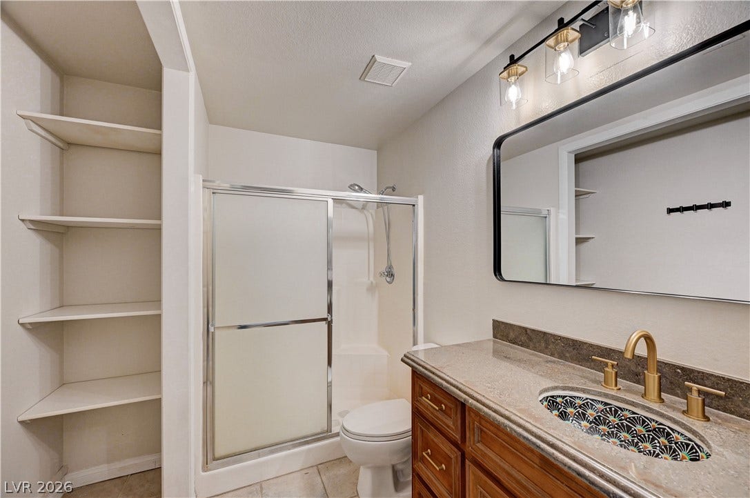 8908 Sheep Ranch Court, Las Vegas, NV 89143 A stylish vanity with stone countertops highlights this functional modern bathroom.