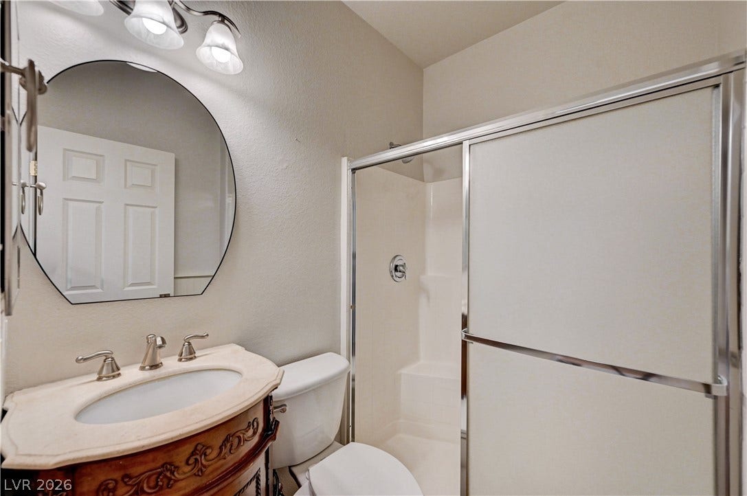 8908 Sheep Ranch Court, Las Vegas, NV 89143 A stylish vanity with stone counters complements the walk-in shower with sliding glass doors.