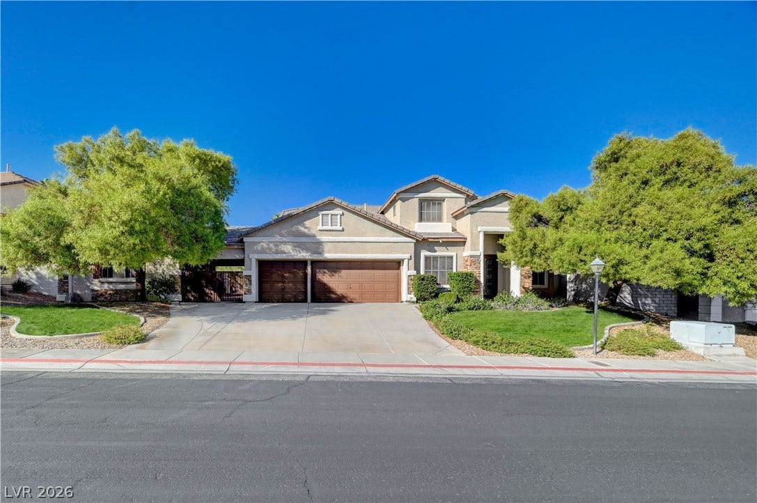8908 Sheep Ranch Court, Las Vegas, NV 89143 Mature trees frame a welcoming facade complete with a multi-car garage and manicured lawns.