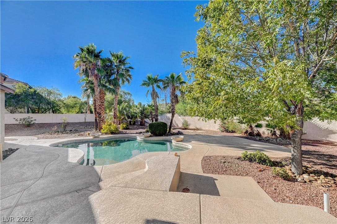 8908 Sheep Ranch Court, Las Vegas, NV 89143 Mature trees and palm trees surround a sparkling swimming pool in this private backyard oasis.