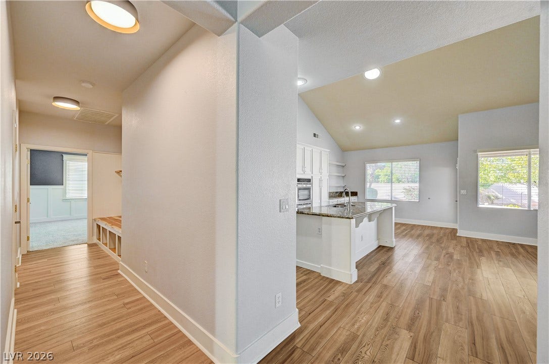 8908 Sheep Ranch Court, Las Vegas, NV 89143 Gleaming wood-look floors anchor this airy, open-concept main level featuring vaulted ceilings.