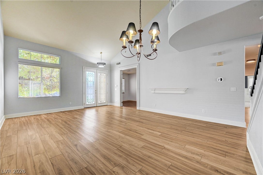 8908 Sheep Ranch Court, Las Vegas, NV 89143 Gleaming wood-look floors pair beautifully with high vaulted ceilings and a classic chandelier.
