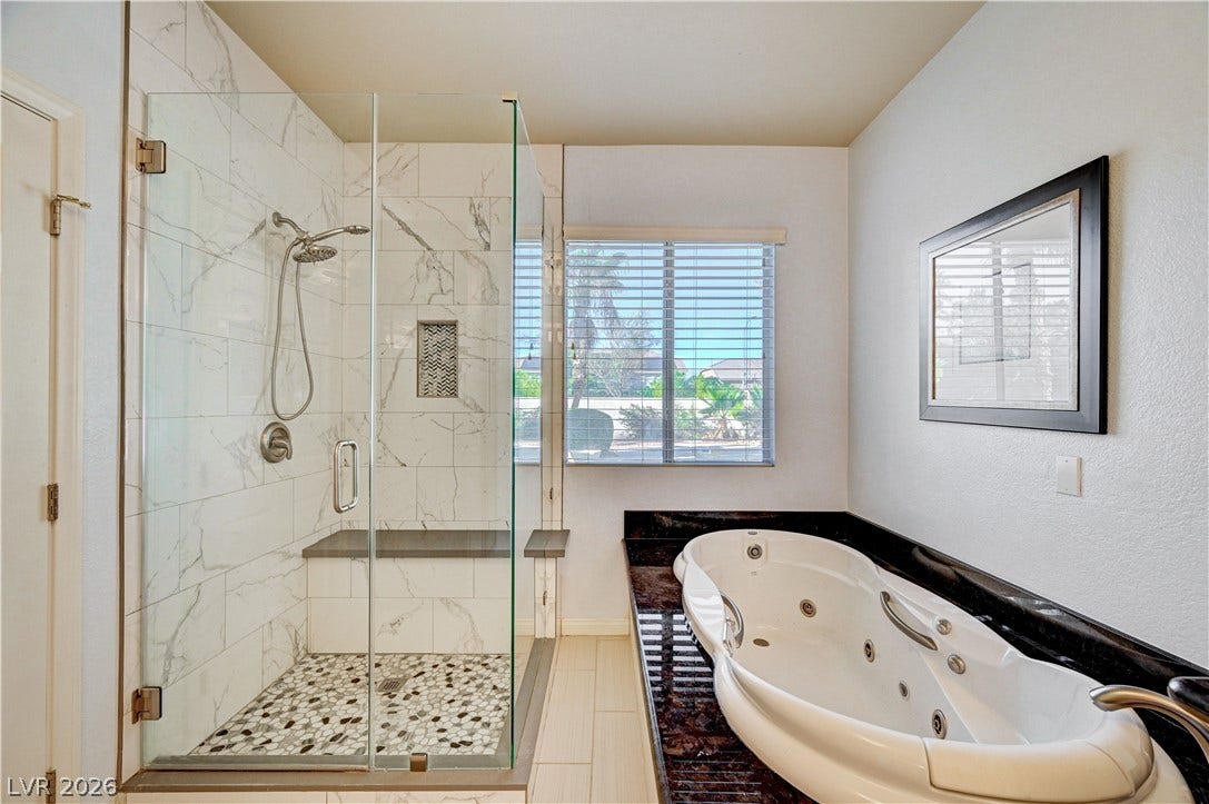 8908 Sheep Ranch Court, Las Vegas, NV 89143 Marble-patterned tile shower and large soaking tub define this relaxing bathroom space.