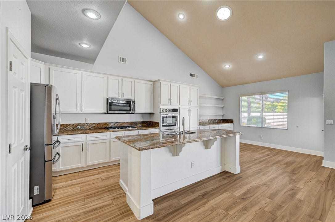 8908 Sheep Ranch Court, Las Vegas, NV 89143 Vaulted ceilings soar over a spacious kitchen anchored by a large granite-topped island.