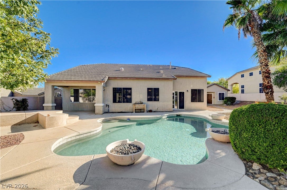 8908 Sheep Ranch Court, Las Vegas, NV 89143 A sparkling freeform pool highlights the concrete patio behind this classic tile-roof residence.