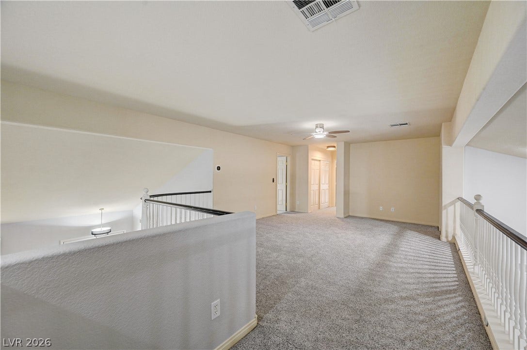 8908 Sheep Ranch Court, Las Vegas, NV 89143 An airy upstairs loft features plush carpeting and white safety railings overlooking the lower level.