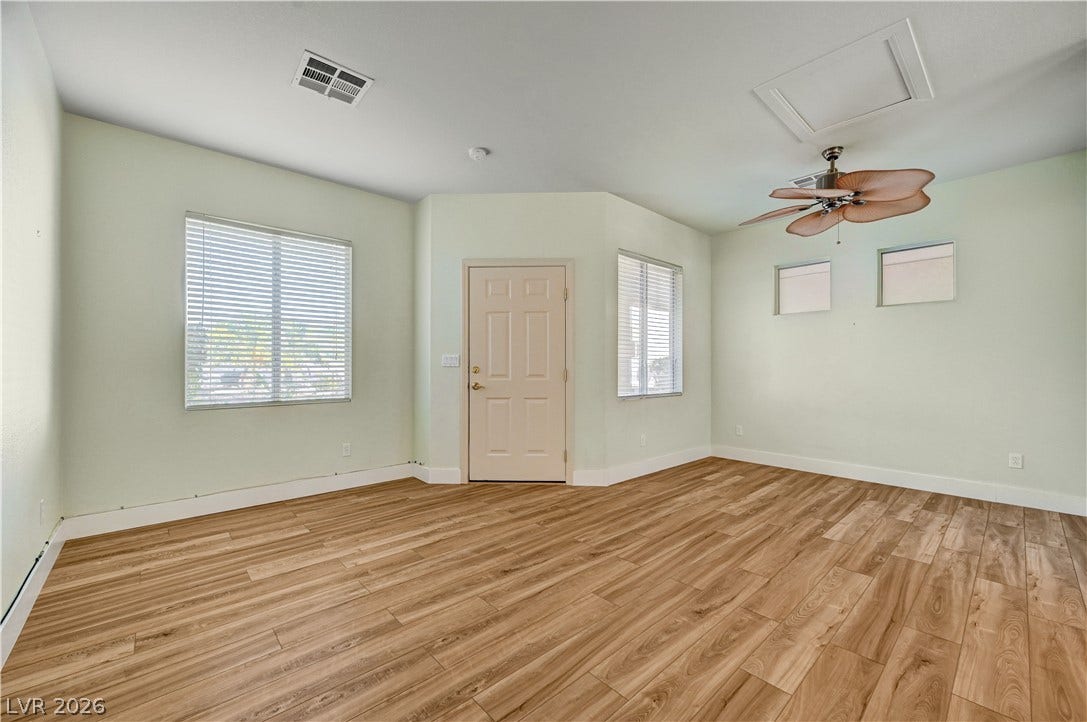 8908 Sheep Ranch Court, Las Vegas, NV 89143 Smooth wood-style flooring and multiple windows define this versatile living space.
