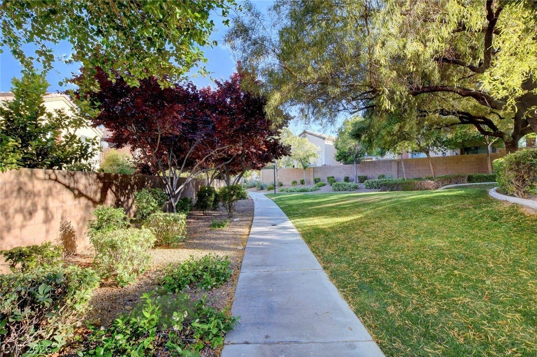 8908 Sheep Ranch Court, Las Vegas, NV 89143 A paved concrete path meanders through manicured lawns and mature shade trees.