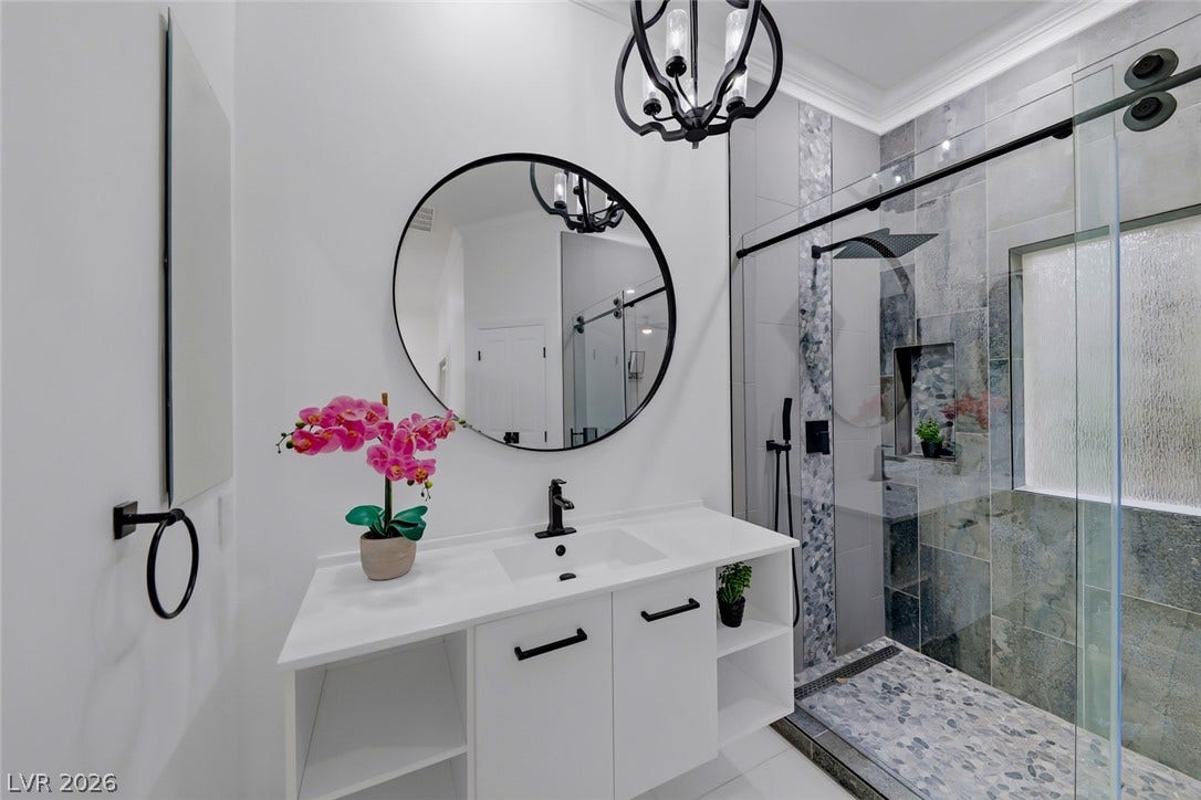 26 Strada Di Circolo, #n/a, Henderson, NV 89011 Polished tile surrounds a glass-enclosed walk-in shower in this modern bathroom.