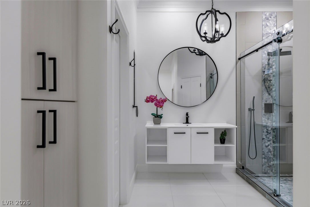 26 Strada Di Circolo, #n/a, Henderson, NV 89011 Modern cabinetry and a glass-enclosed shower elevate this elegant bathroom space.