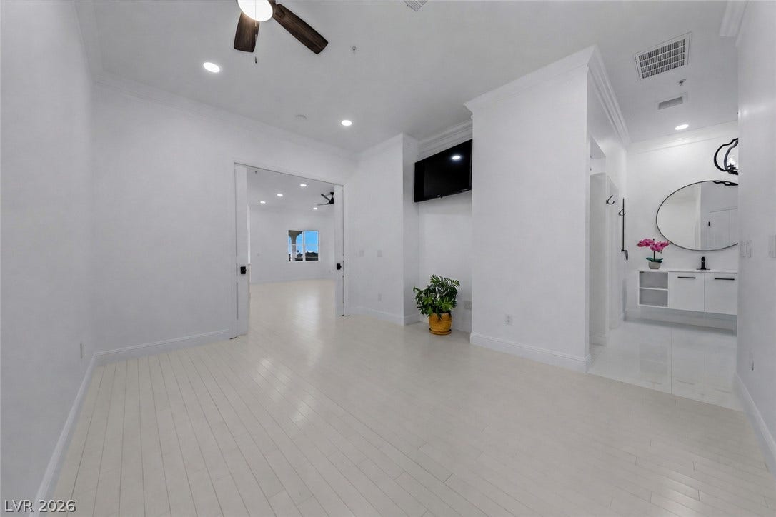 26 Strada Di Circolo, #n/a, Henderson, NV 89011 Clean lines and smooth flooring define this minimalist interior suite with an adjacent vanity area.