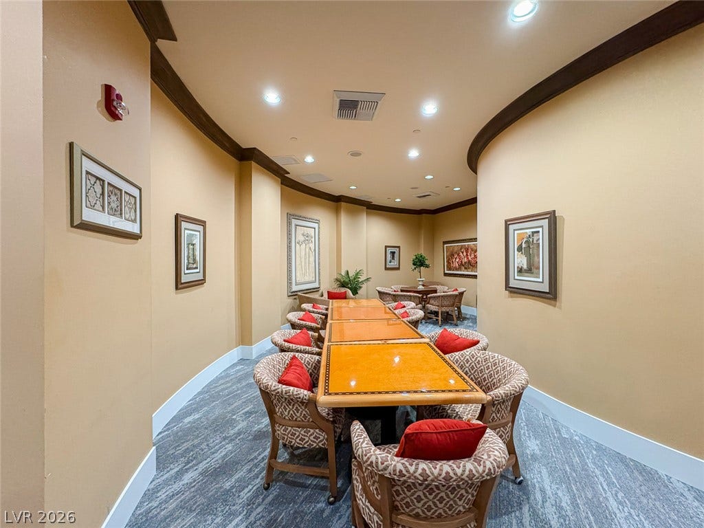 26 Strada Di Circolo, #n/a, Henderson, NV 89011 Curved plaster walls and crown molding frame a long meeting room with carpeted flooring.