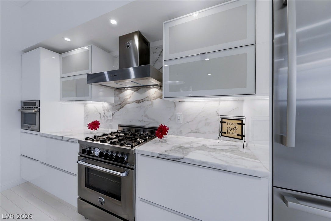26 Strada Di Circolo, #n/a, Henderson, NV 89011 Sleek modern cabinetry and stone countertops frame a high-end stainless steel gas range.