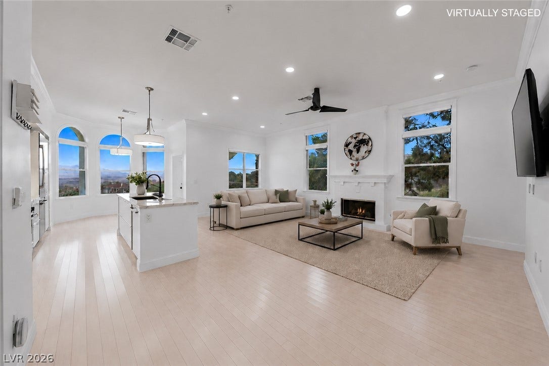 26 Strada Di Circolo, #n/a, Henderson, NV 89011 Polished wood floors stretch across a light-filled great room anchored by a fireplace.