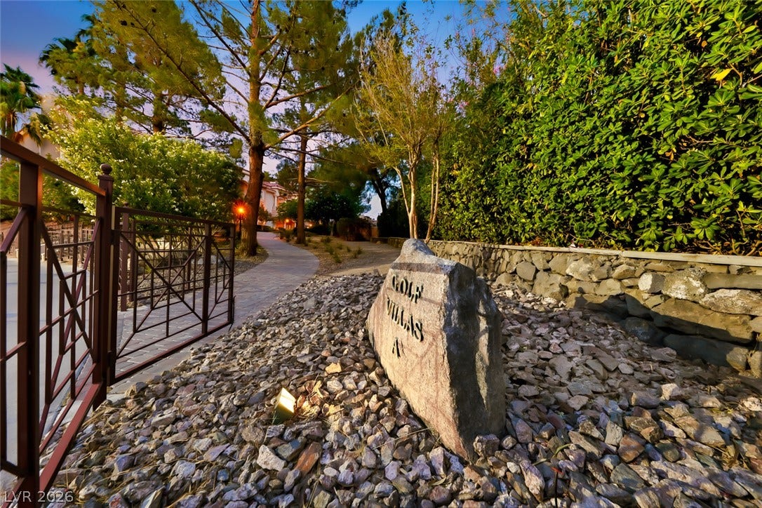 26 Strada Di Circolo, #n/a, Henderson, NV 89011 Mature trees and low stone walls frame the winding paved pathway through the gated entrance.