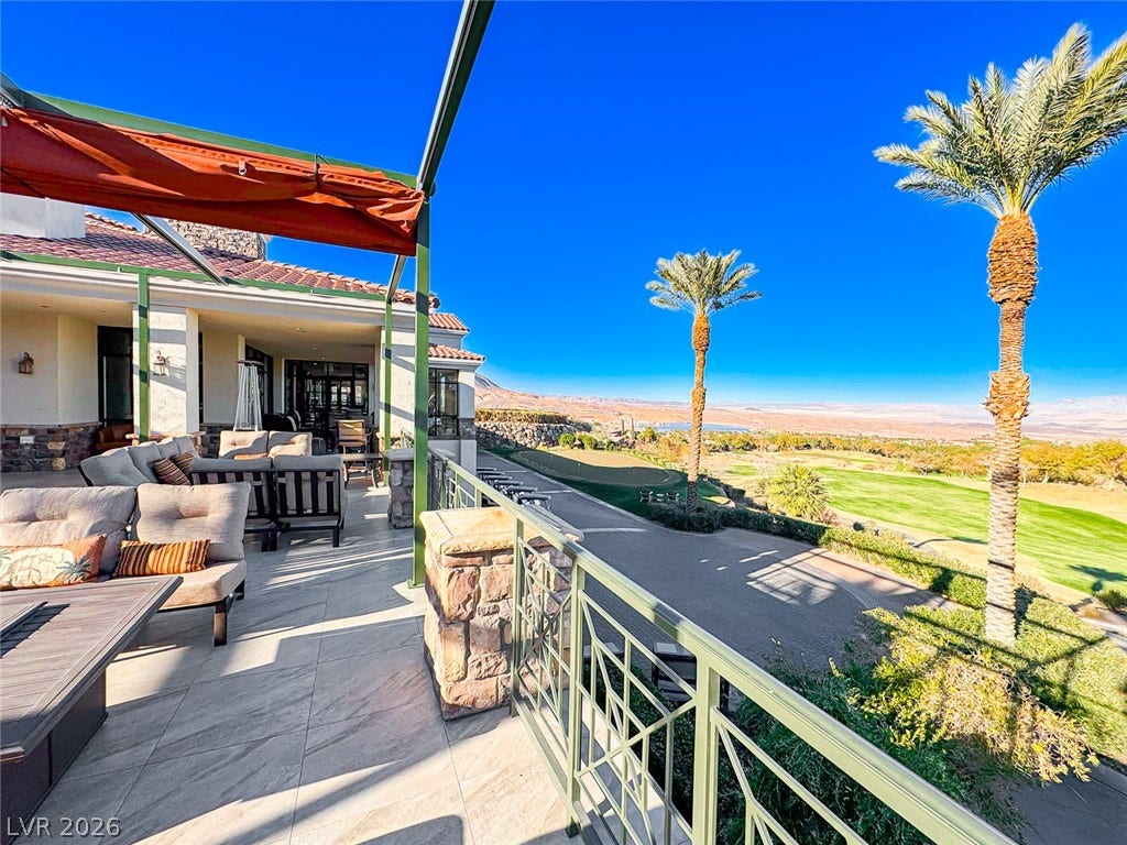 26 Strada Di Circolo, #n/a, Henderson, NV 89011 An elevated stone-tiled patio showcases metal railings and sweeping views across the golf course.
