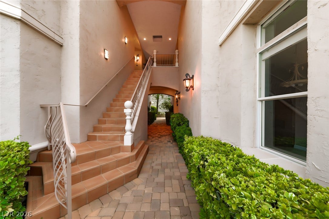 26 Strada Di Circolo, #n/a, Henderson, NV 89011 An inviting stone pathway and tiled staircase lead through a covered architectural passage.