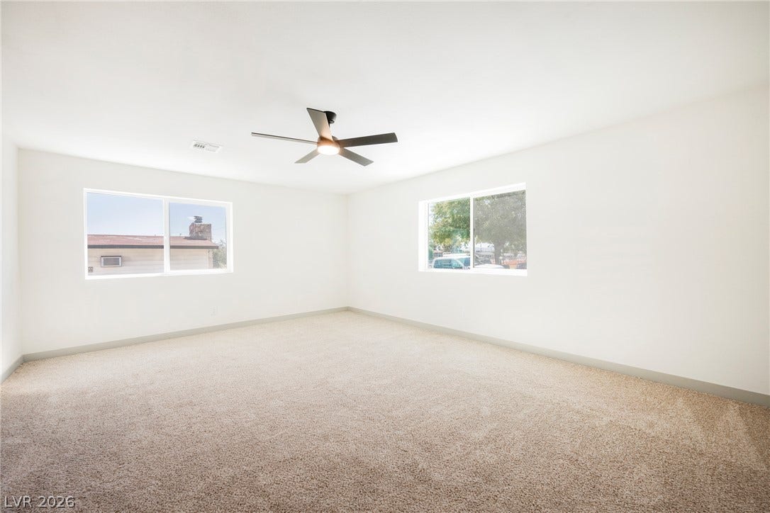 Soft wall-to-wall carpeting and multiple sliding windows create a serene, airy atmosphere.