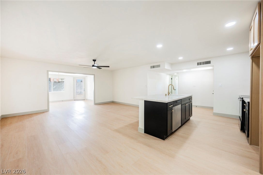 Clean lines and smooth flooring define this light-filled, open-concept kitchen and living area.