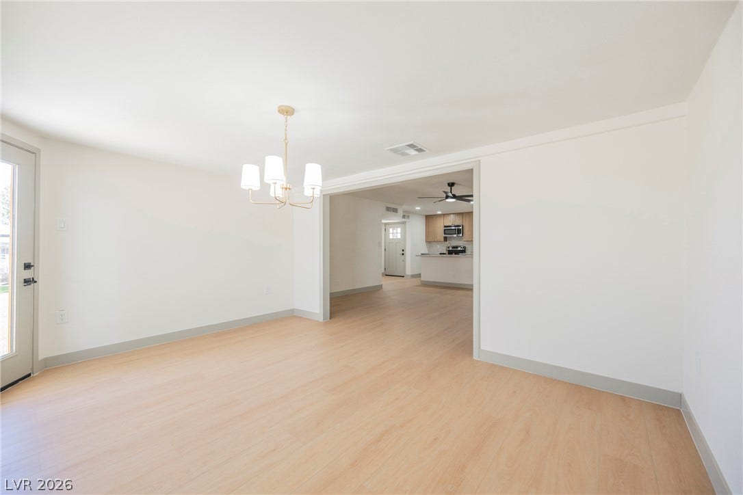Clean lines and smooth flooring define this versatile dining area opening to the kitchen.