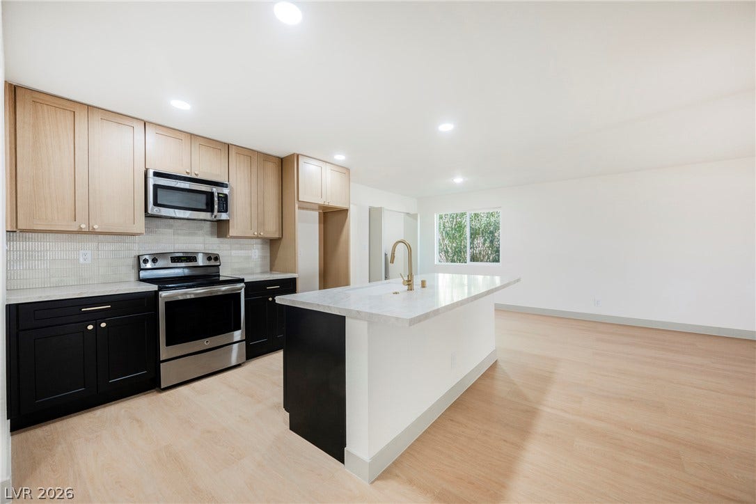 An open floor plan seamlessly connects the modern kitchen with the adjacent living space.