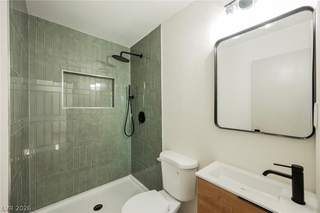 Modern vertical tile accents the walk-in shower of this updated bathroom.