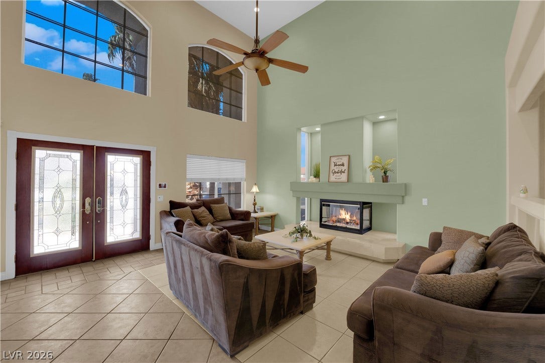 9852 Snowy Canyon Court, Las Vegas, NV 89183 Soaring ceilings and a cozy fireplace define this airy living space with tile flooring.