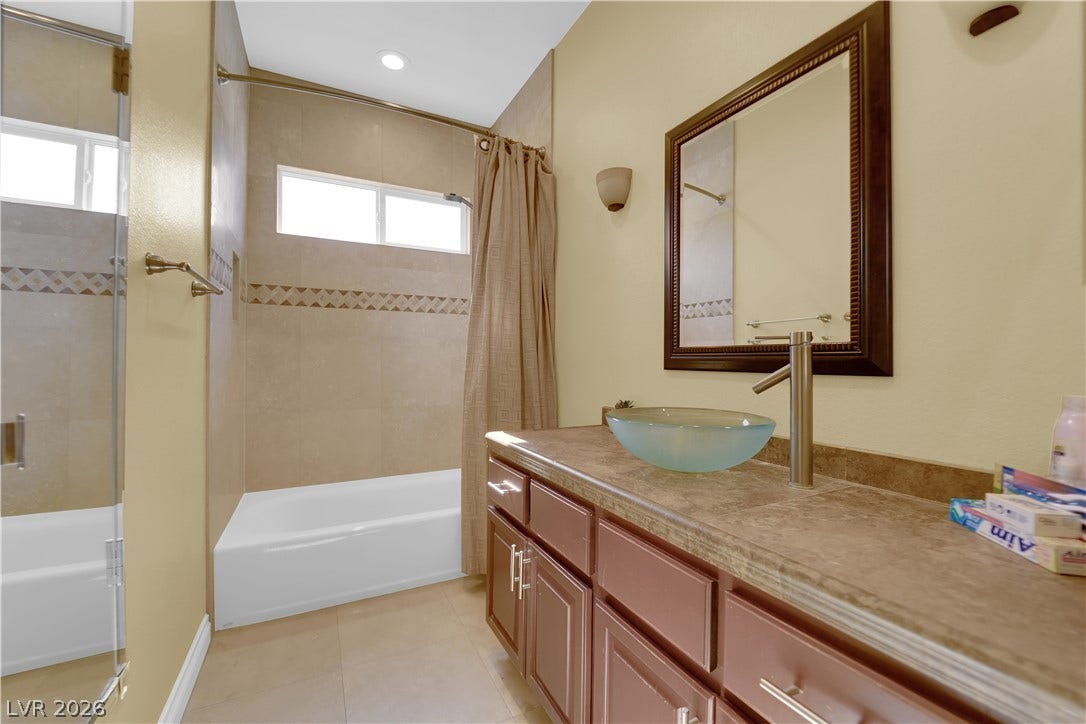 9852 Snowy Canyon Court, Las Vegas, NV 89183 Tiled flooring complements a generous vanity counter and a modern vessel sink in this bathroom.