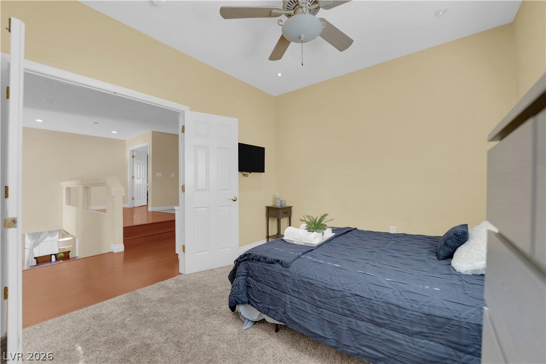 9852 Snowy Canyon Court, Las Vegas, NV 89183 Double doors open to a comfortable bedroom featuring plush carpeting and recessed lighting.