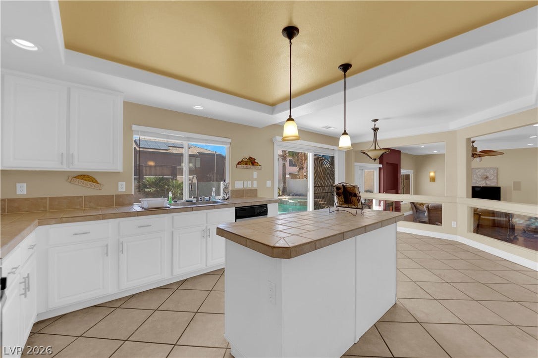 9852 Snowy Canyon Court, Las Vegas, NV 89183 A spacious tiled kitchen features a central island and a recessed ceiling design.