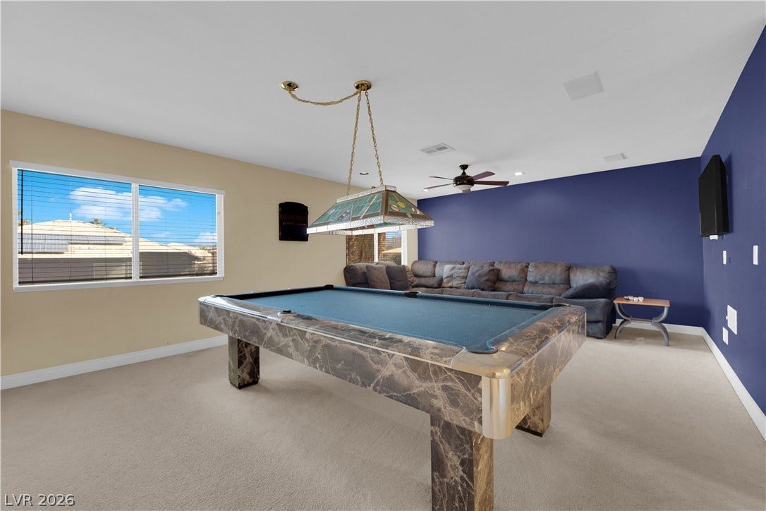 9852 Snowy Canyon Court, Las Vegas, NV 89183 Wall-to-wall carpeting and smooth plaster walls define this versatile recreation space.