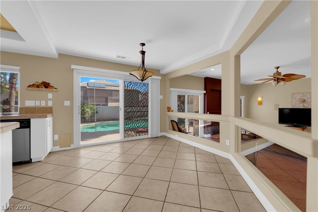 9852 Snowy Canyon Court, Las Vegas, NV 89183 Tiled flooring and broad sliding glass doors define this open dining area overlooking the pool.