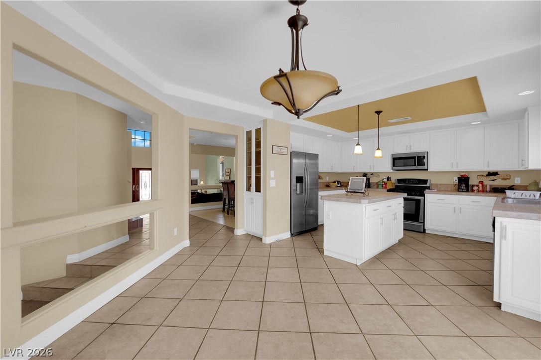9852 Snowy Canyon Court, Las Vegas, NV 89183 Tiled flooring flows through this kitchen design featuring a central island and recessed ceilings.
