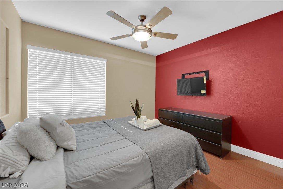 9852 Snowy Canyon Court, Las Vegas, NV 89183 A spacious bedroom features rich hardwood flooring and a large window providing ample natural light.