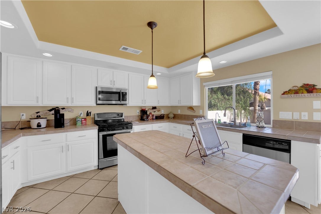 9852 Snowy Canyon Court, Las Vegas, NV 89183 An airy culinary workspace showcases a spacious center island and clean white cabinetry.