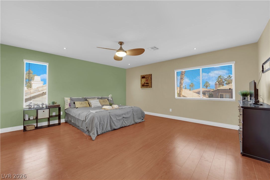 9852 Snowy Canyon Court, Las Vegas, NV 89183 Rich wood flooring runs throughout this spacious bedroom with recessed lighting and large windows.