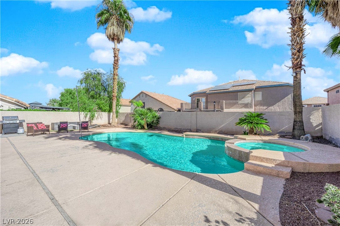 9852 Snowy Canyon Court, Las Vegas, NV 89183 An inviting backyard oasis features a curved swimming pool and matching elevated spa.