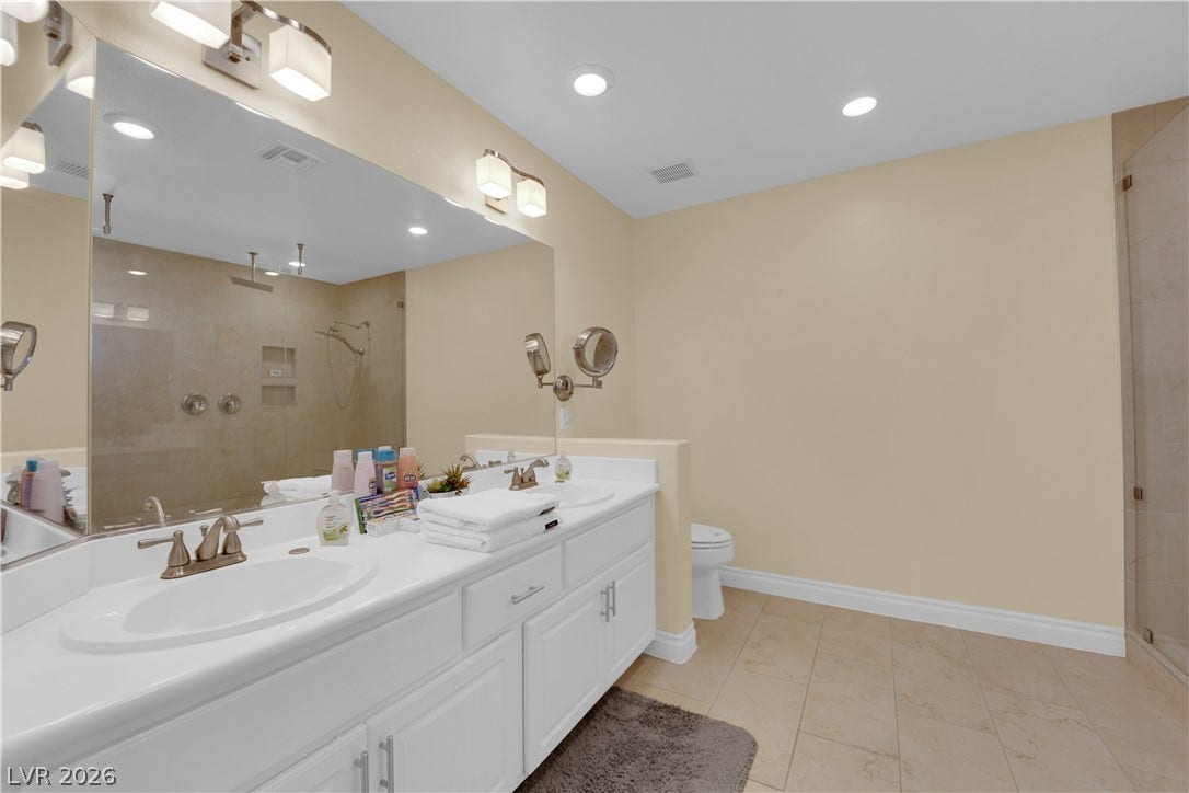9852 Snowy Canyon Court, Las Vegas, NV 89183 Gleaming tile floors and a wide dual vanity define this updated bathroom space.