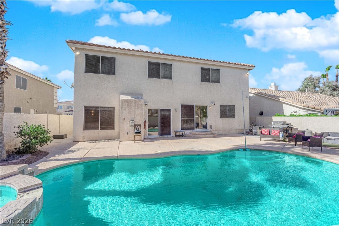 9852 Snowy Canyon Court, Las Vegas, NV 89183 An inviting backyard oasis features a shimmering private swimming pool alongside spacious concrete lounging patios.