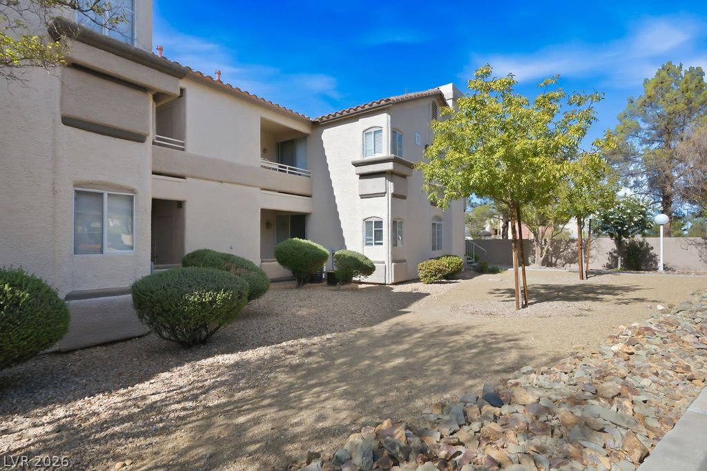 75 N Valle Verde Drive, #311, Henderson, NV 89074 Manicured desert landscaping borders the stucco exterior of this multi-level residential building.