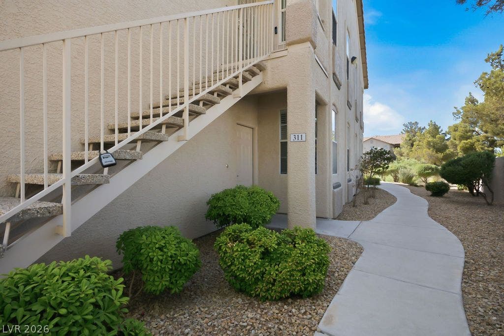 75 N Valle Verde Drive, #311, Henderson, NV 89074 A curved concrete walkway leads to the private entrance of this multi-level stucco residence.
