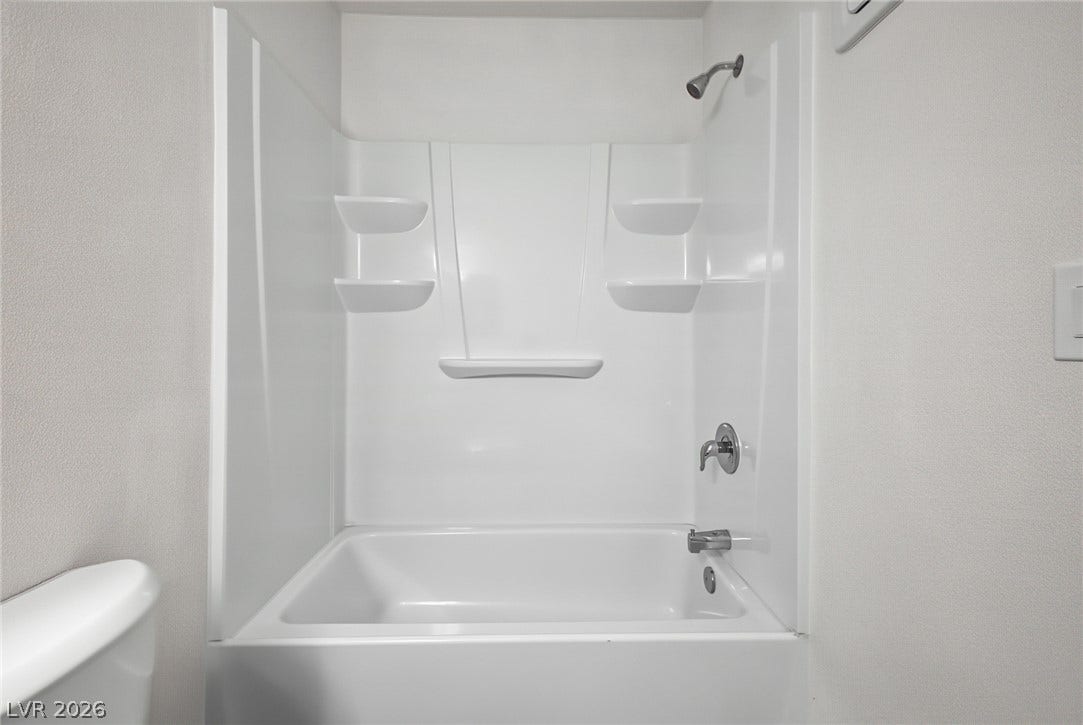 1405 Vegas Valley Drive, #187, Las Vegas, NV 89169 A clean bathtub and shower combination features molded shelving and simple chrome fixtures.