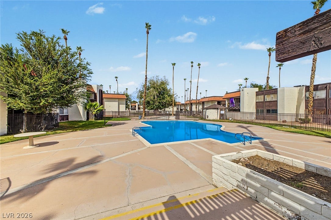 1405 Vegas Valley Drive, #187, Las Vegas, NV 89169 A sparkling blue swimming pool sits centered within a spacious concrete deck under clear skies.
