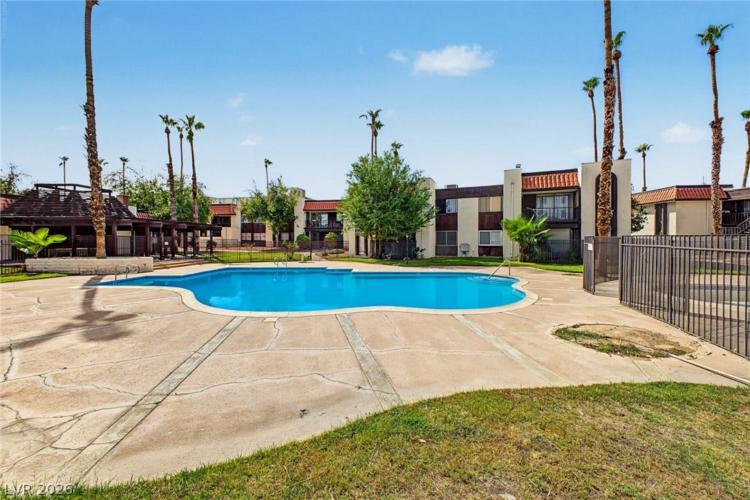 1405 Vegas Valley Drive, #187, Las Vegas, NV 89169 A sparkling community swimming pool rests under towering palm trees and clear blue skies.